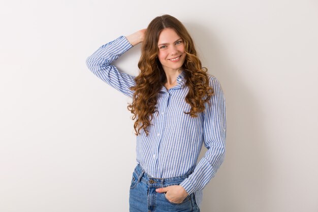 Vrij stijlvolle jonge vrouw poseren in denim stijl outfit op wit