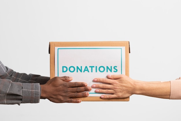 Vrijwilliger geeft een doos met donaties aan een andere vrijwilliger