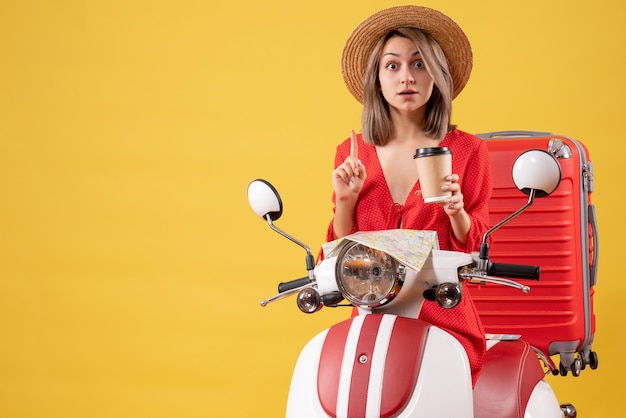 vroeg zich af jonge dame in rode jurk met koffiekopje in de buurt van bromfiets