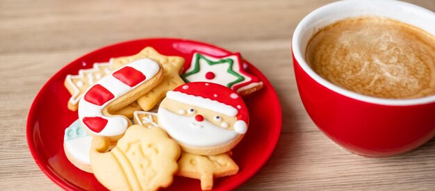 Vrolijk kerstfeest met zelfgemaakte koekjes en koffiekopje op houten tafel achtergrond. kerstavond, feest, vakantie en gelukkig nieuwjaar concept Premium Foto