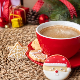 Vrolijk kerstfeest met zelfgemaakte koekjes en koffiekopje op houten tafel achtergrond. kerstavond, feest, vakantie en gelukkig nieuwjaarsconcept