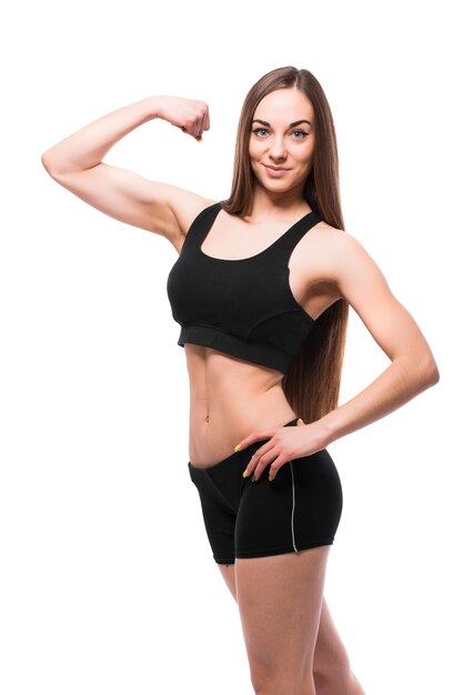 Vrolijk lachende gemengde race sportieve vrouw biceps demonstreren, geïsoleerd op een witte achtergrond
