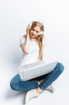 Vrolijk meisje die aan computer werken en aan geïsoleerd, gelukkig en leuke muziek luisteren