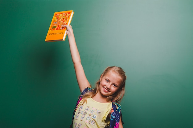 Vrolijk meisje met boek in de klas