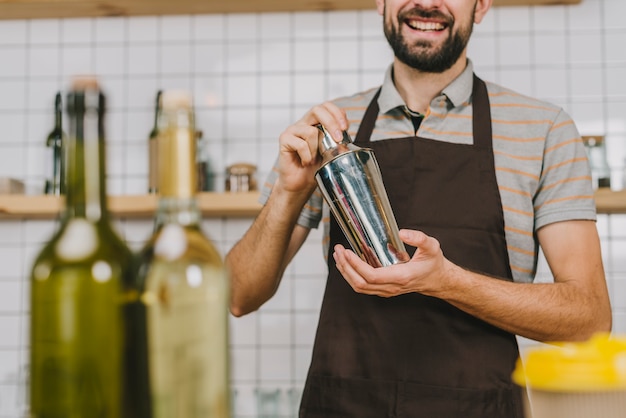 Gratis foto vrolijke barman die cocktail mengt