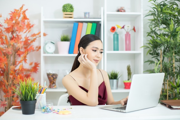 Vrolijke bedrijfsdame die aan laptop in bureau werkt