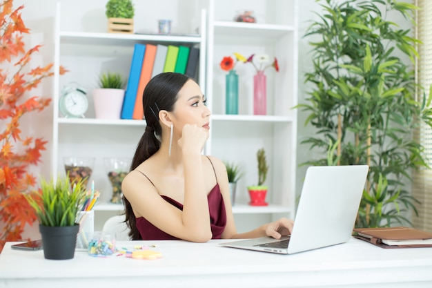 Vrolijke bedrijfsdame die aan laptop in bureau werkt