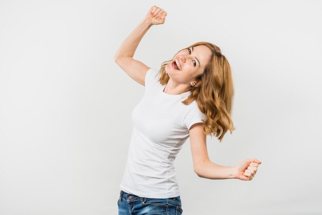 Vrolijke blonde jonge die vrouw op witte achtergrond wordt geïsoleerd