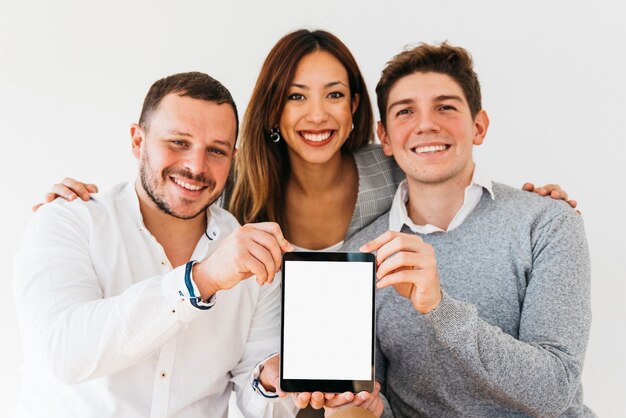 Vrolijke collega&#39;s die nieuwe tablet voorstellen