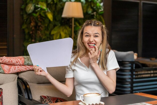 Vrolijke dame die een wit ideebord vasthoudt en lacht