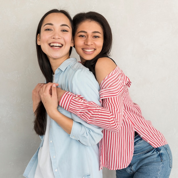 Gratis foto vrolijke dames die en voor camera glimlachen stellen