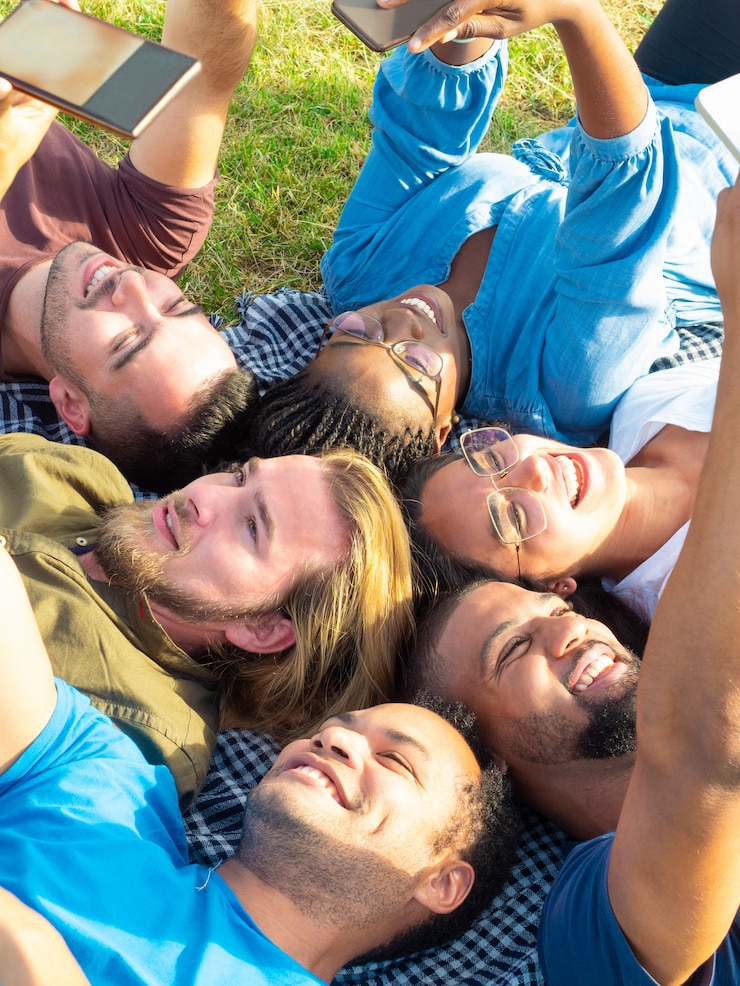 Gratis Foto vrolijke en vriend die smartphones liggen houden