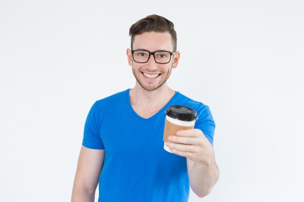 Vrolijke energetische jonge man met uitgaand koffie