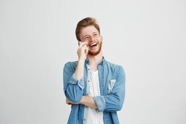 Vrolijke gelukkig jonge man lachen glimlachen praten over de telefoon.