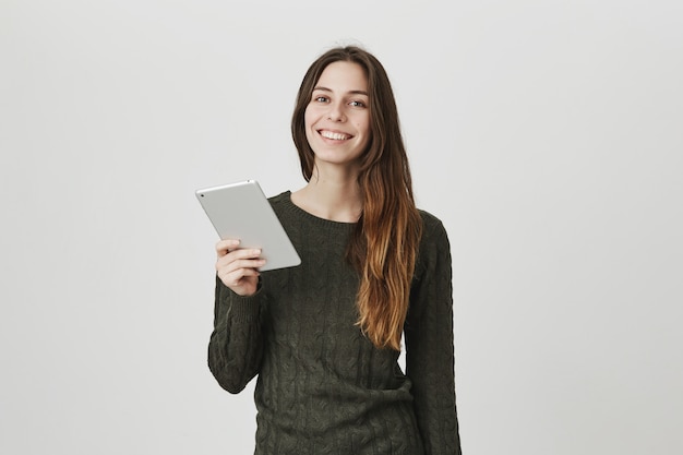 Vrolijke glimlachende mooie vrouw met digitale tablet