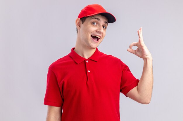 Vrolijke jonge blanke bezorger in rood shirt gebaren ok teken