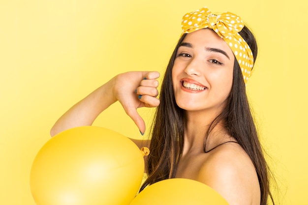 Vrolijke jonge dame die ballonnen vasthoudt en lacht voor de camera