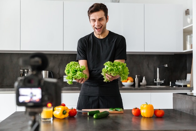 Vrolijke jonge man die zijn videoblog-aflevering filmt