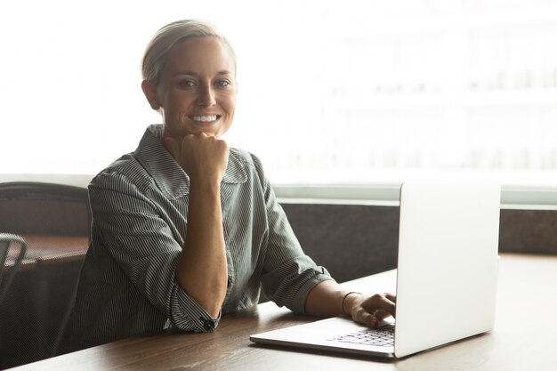 Vrolijke jonge zakenvrouw werken op laptop