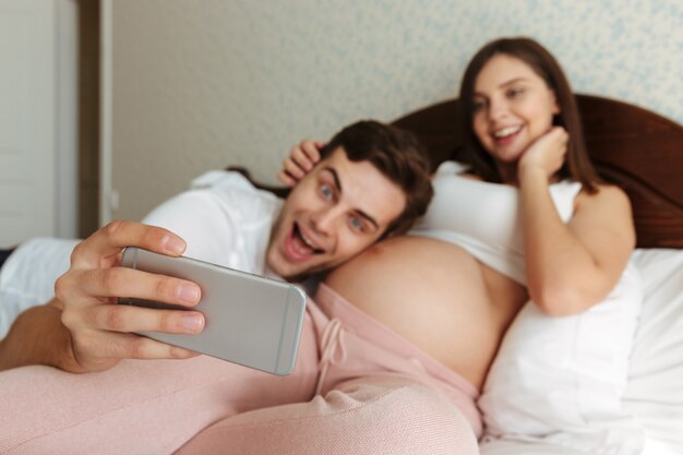 Vrolijke jonge zwangere paar selfie te nemen
