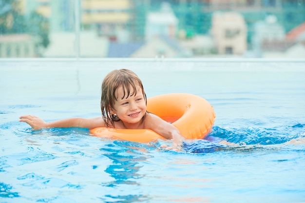 Vrolijke jongen die in pool zwemt