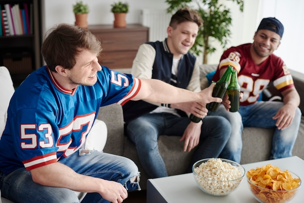 Vrolijke jongens chillen met drankjes en snacks