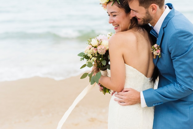 Vrolijke jonggehuwden bij strandhuwelijk ceremnoy
