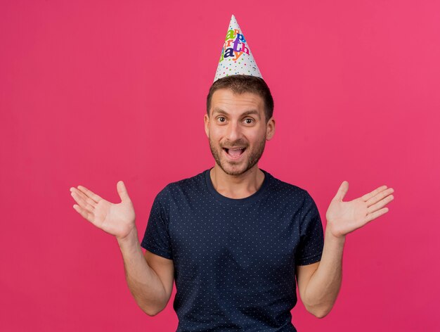 Vrolijke knappe blanke man met verjaardag GLB staat met opgeheven handen geïsoleerd op roze achtergrond met kopie ruimte