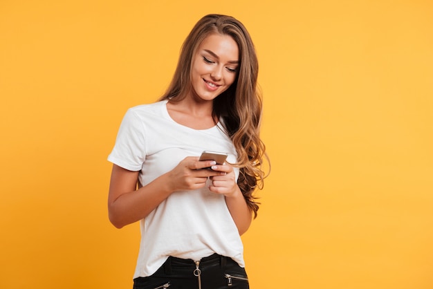 Vrolijke leuke mooie jonge vrouw chatten via de mobiele telefoon