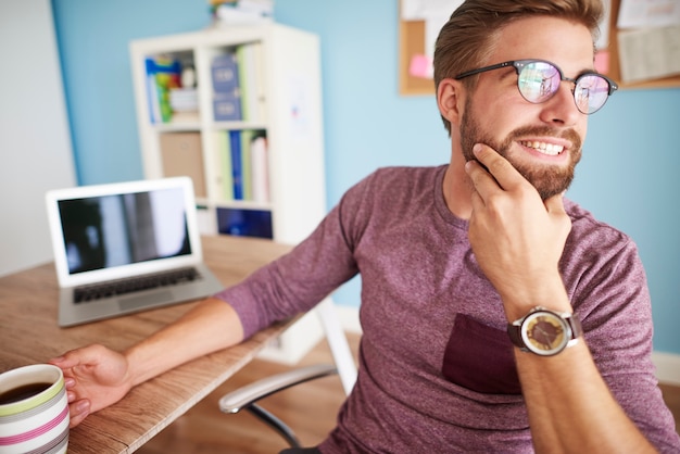 Gratis foto vrolijke man die zich naar het raam wendt