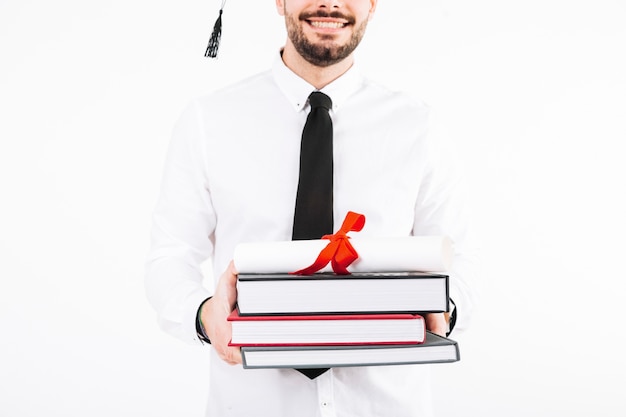 Gratis foto vrolijke man met diploma en boeken