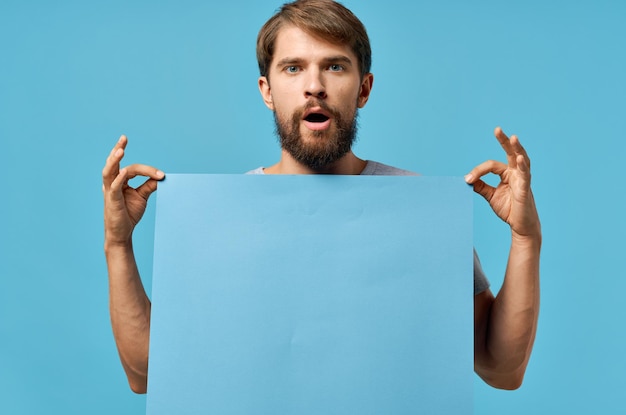 Vrolijke man met een mockup poster korting blauwe achtergrond