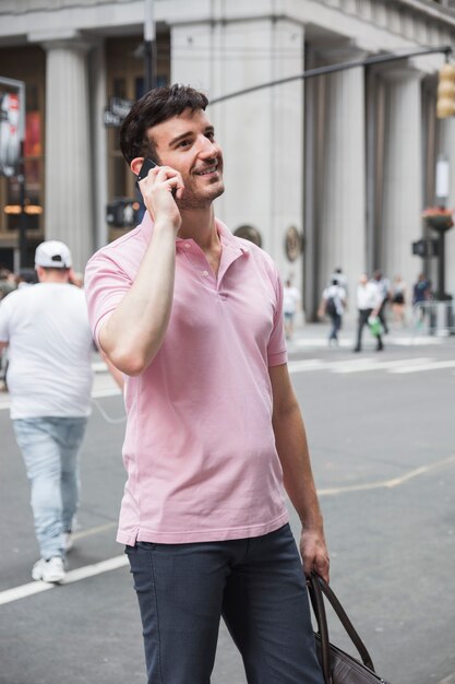 Vrolijke man spreken op smartphone op straat