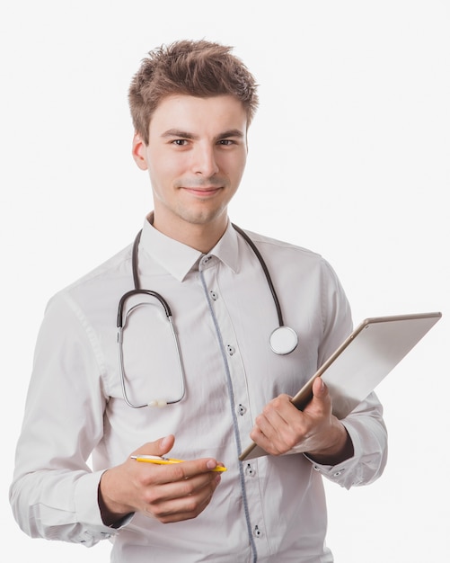 Gratis foto vrolijke mannelijke arts met tablet en pen