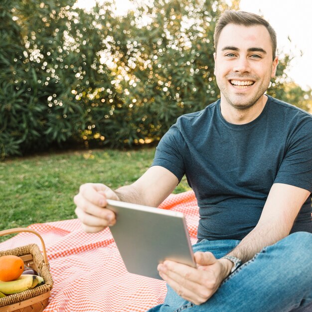 Vrolijke mens die met tablet camera bekijkt