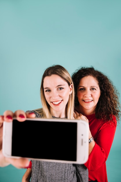 Gratis foto vrolijke moeder en dochter poseren voor selfie