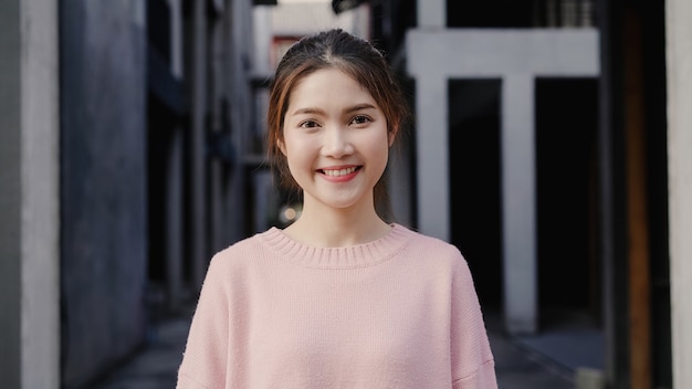 Vrolijke mooie jonge Aziatische vrouw die het gelukkige glimlachen aan camera voelen terwijl het reizen in Chinatown in Peking, China.