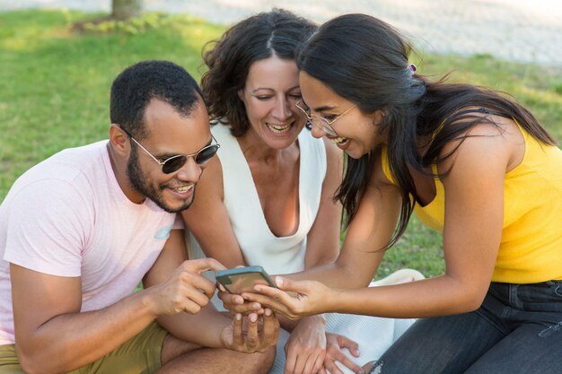 Vrolijke multi-etnische vrienden die smartphone gebruiken