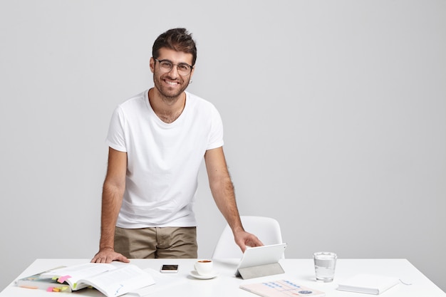 Vrolijke stijlvolle mannelijke freelancer blij met een succesvolle dag