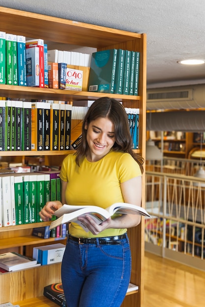 Vrolijke tiener leesboek in schoolbibliotheek