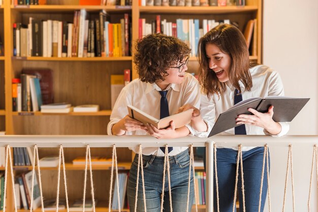 Vrolijke tieners met boeken in de bibliotheek