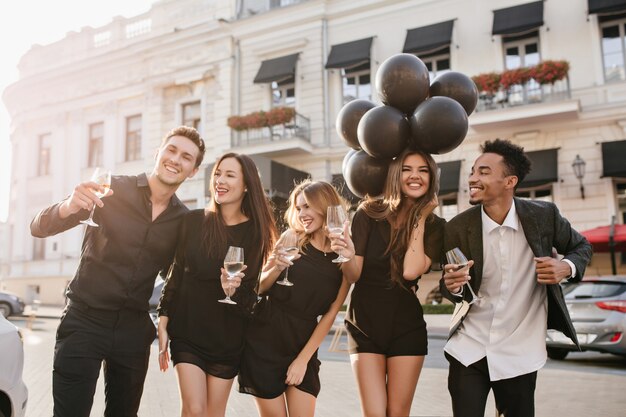 Gratis foto vrolijke vrienden champagne drinken op feestje buiten