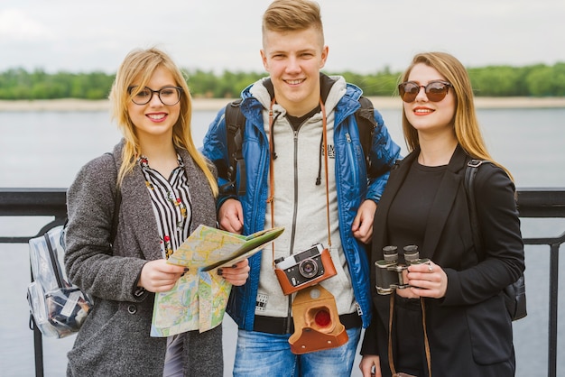 Gratis foto vrolijke vrienden met kaart aan de waterkant