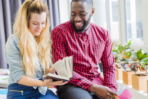 Vrolijke vrienden poseren met boeken