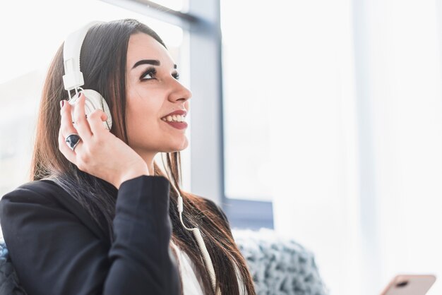 Vrolijke vrouw die aan muziek luistert