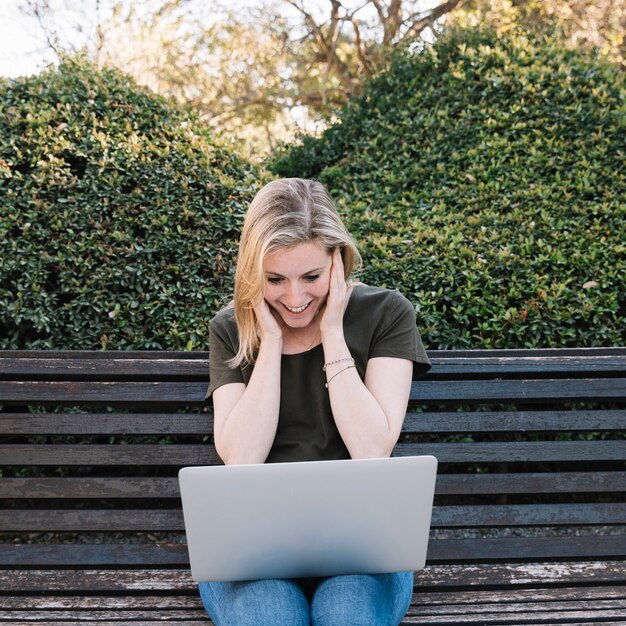 Vrolijke vrouw die laptop bekijkt