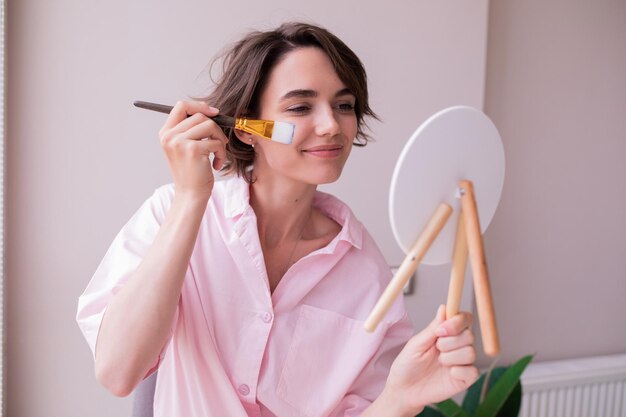 Vrolijke vrouw die masker voor gezicht doet