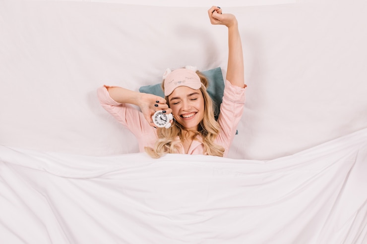 Gratis Foto vrolijke vrouw die zich uitstrekt in bed