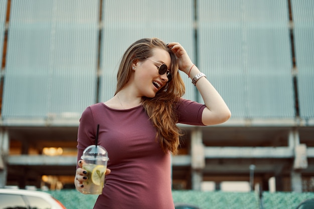 Vrolijke vrouw in de straat het drinken ochtend verfrissende drank