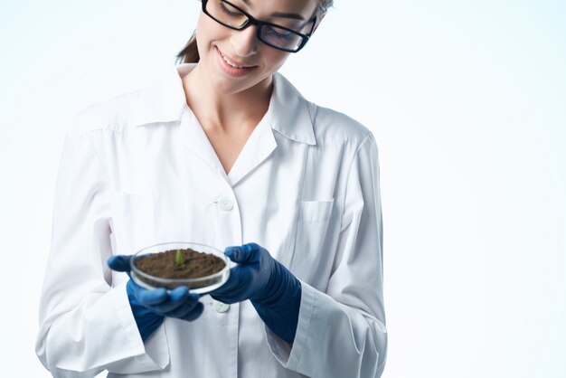 Vrolijke vrouw in witte jas student wetenschap biotechnologie planten
